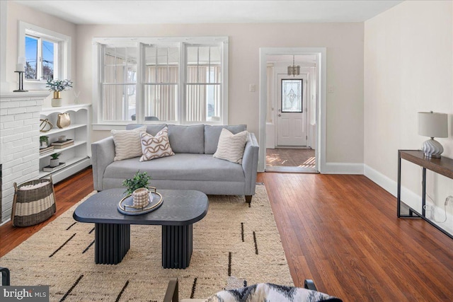 living area featuring baseboards, wood-type flooring, and a baseboard radiator