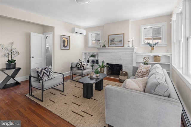 living room with plenty of natural light, a fireplace, a wall mounted AC, and wood finished floors