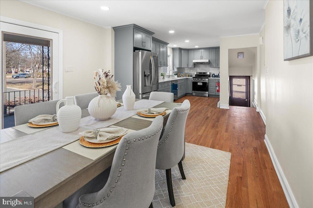 dining space featuring recessed lighting, wood finished floors, and baseboards