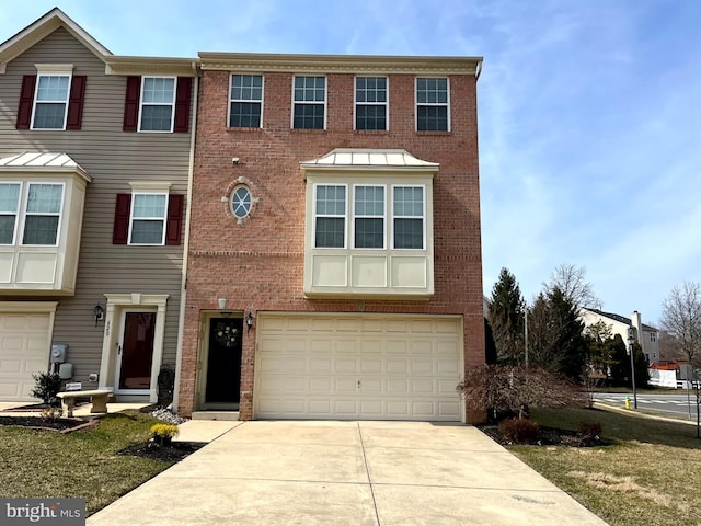 townhome / multi-family property with brick siding, an attached garage, and concrete driveway