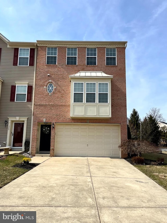 view of front of property featuring brick siding, concrete driveway, and an attached garage