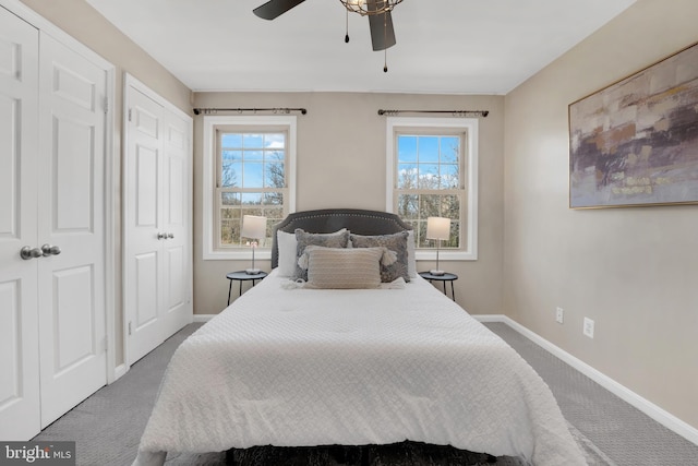 bedroom with baseboards, multiple closets, a ceiling fan, and carpet flooring