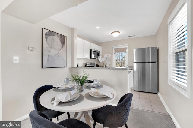 dining space featuring visible vents, baseboards, and light tile patterned flooring