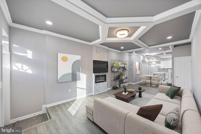 living area featuring coffered ceiling, wood finished floors, a high end fireplace, crown molding, and baseboards