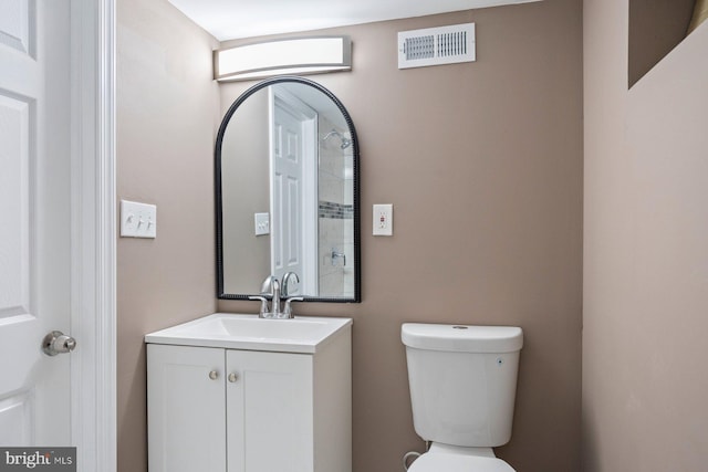 bathroom featuring visible vents, toilet, and vanity