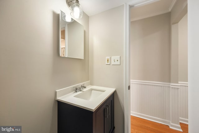 bathroom featuring a wainscoted wall, wood finished floors, and vanity