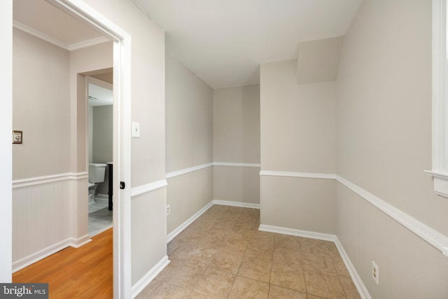 corridor featuring a wainscoted wall