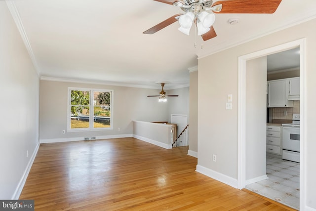 empty room with crown molding, light wood-style flooring, baseboards, and ceiling fan