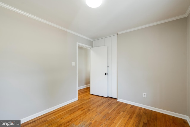 unfurnished room with baseboards, light wood-style flooring, and ornamental molding