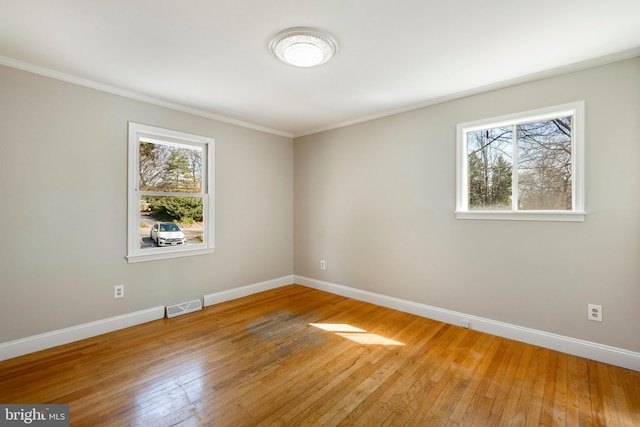 unfurnished room featuring visible vents, plenty of natural light, and baseboards