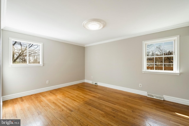 unfurnished room featuring a healthy amount of sunlight, visible vents, and baseboards