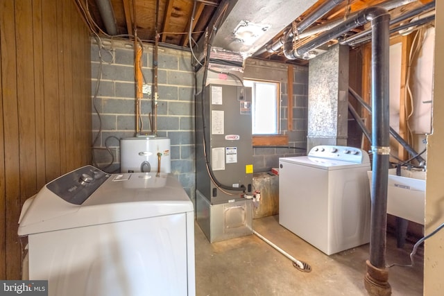 laundry room with heating unit, laundry area, washing machine and dryer, and gas water heater