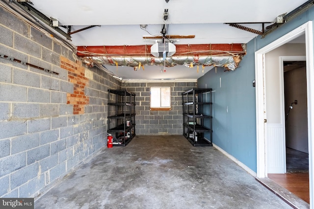 garage with concrete block wall and a garage door opener