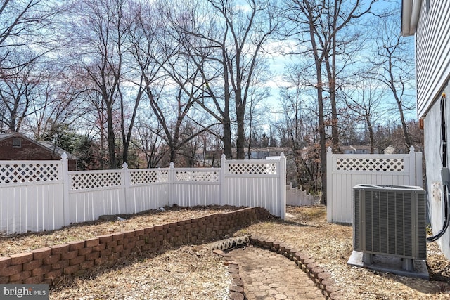 view of yard with central AC unit and fence