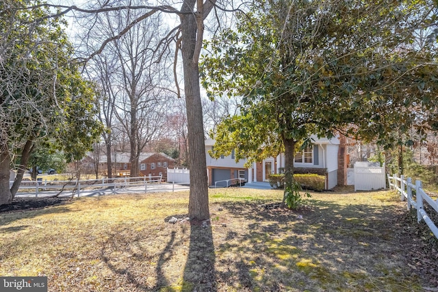 view of yard featuring a garage and fence