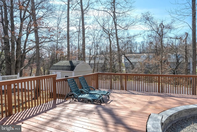 wooden terrace featuring a storage unit and an outbuilding