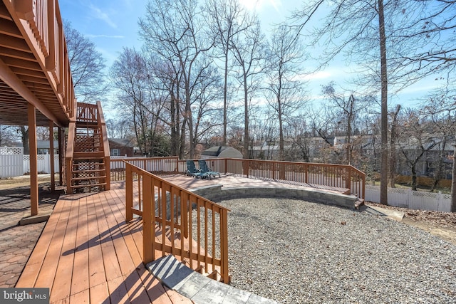 wooden terrace featuring an outdoor structure, stairs, and fence