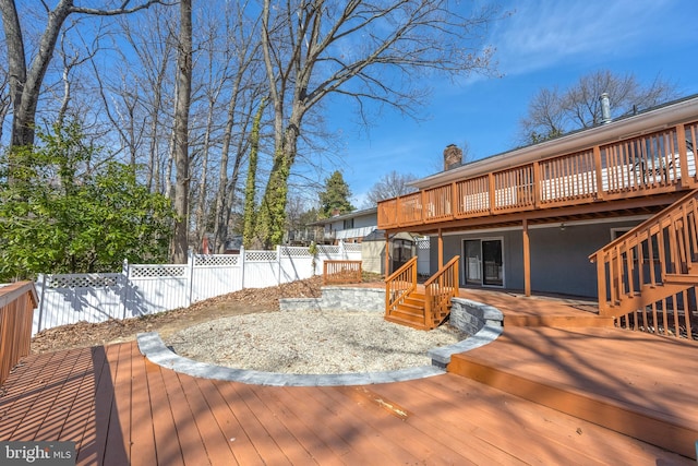 deck with an outbuilding, a fenced backyard, and a shed