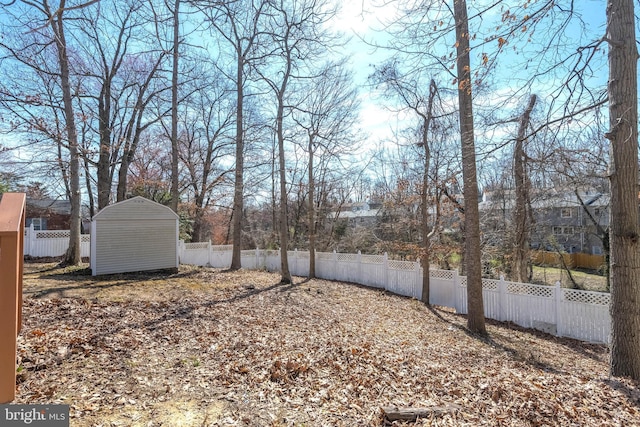 view of yard featuring an outbuilding, a fenced backyard, and a shed