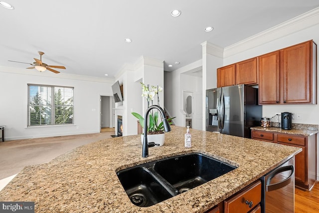 kitchen featuring crown molding, ceiling fan, stainless steel fridge with ice dispenser, open floor plan, and a sink