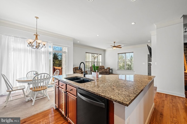 kitchen featuring dark stone countertops, light wood finished floors, ornamental molding, a sink, and dishwasher