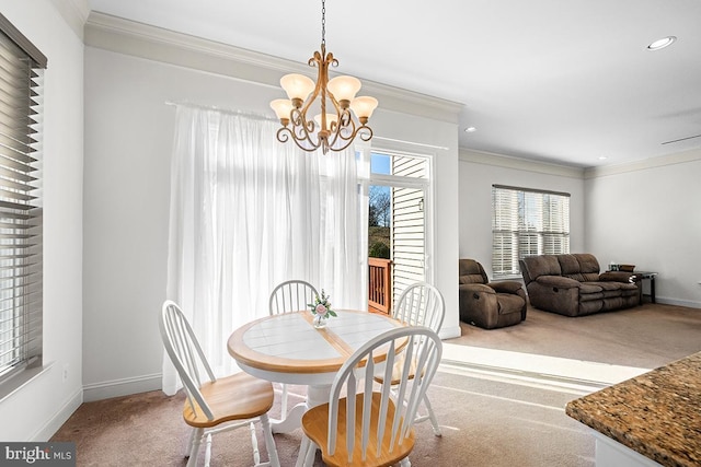 dining area with crown molding, carpet, baseboards, and a chandelier