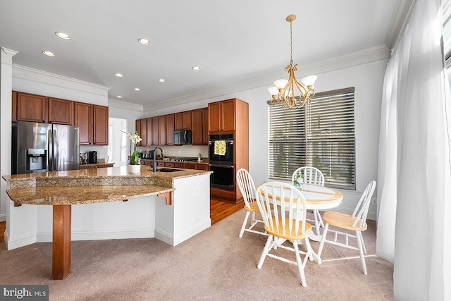 kitchen with black appliances, a kitchen island with sink, a sink, an inviting chandelier, and crown molding