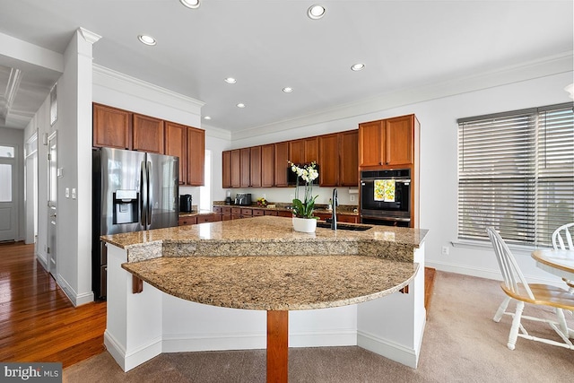 kitchen with an island with sink, dobule oven black, a sink, recessed lighting, and crown molding