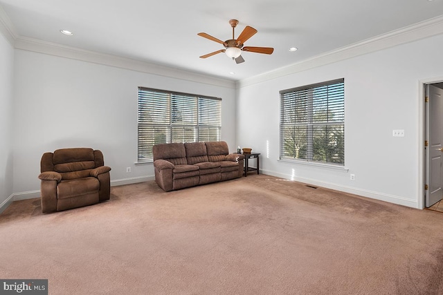 living area with baseboards, ceiling fan, and ornamental molding