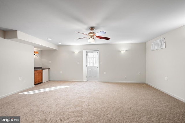 unfurnished living room featuring recessed lighting, light colored carpet, baseboards, and ceiling fan