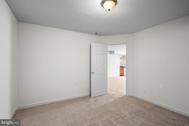 unfurnished room with carpet and baseboards