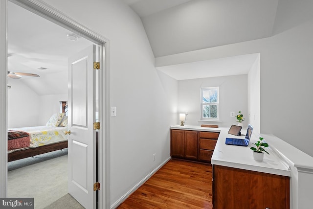 ensuite bathroom with ensuite bath, wood finished floors, ceiling fan, vanity, and vaulted ceiling