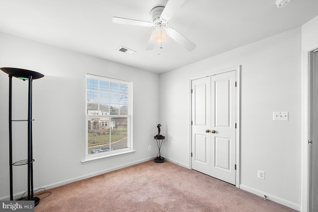 unfurnished bedroom featuring visible vents, carpet floors, baseboards, and a ceiling fan