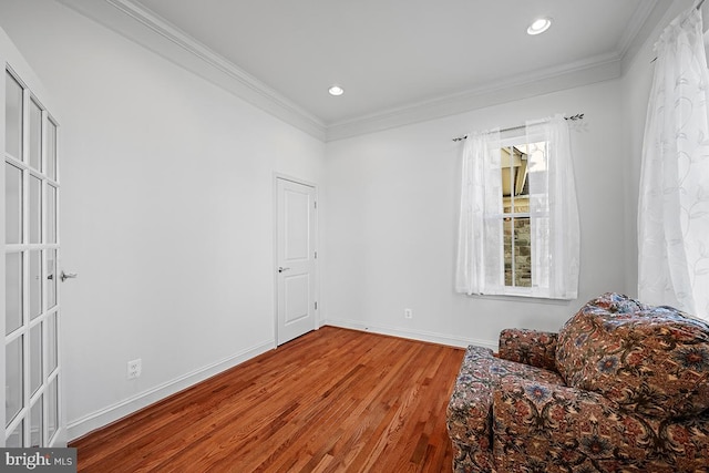 living area with recessed lighting, baseboards, wood finished floors, and ornamental molding