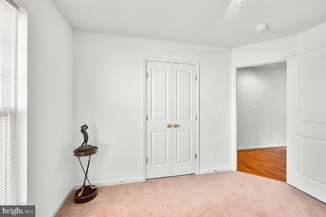 unfurnished bedroom featuring carpet, a closet, and baseboards