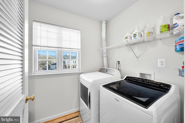 laundry room featuring light wood-style floors, laundry area, baseboards, and independent washer and dryer