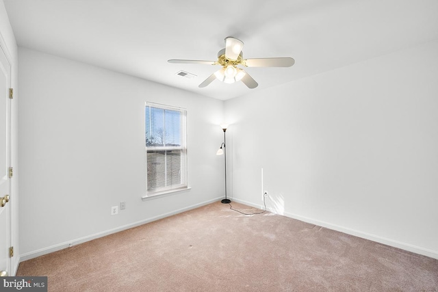 empty room featuring visible vents, baseboards, carpet, and a ceiling fan