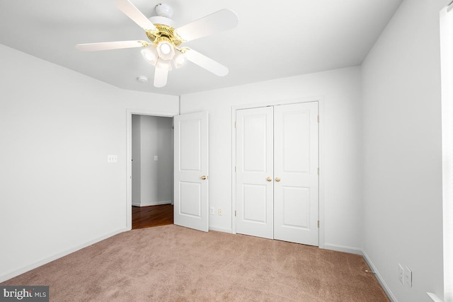 unfurnished bedroom featuring a closet, baseboards, ceiling fan, and carpet floors