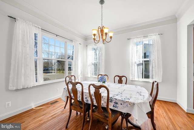 dining space with a notable chandelier, wood finished floors, baseboards, and ornamental molding