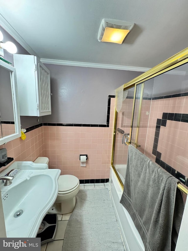 full bathroom featuring toilet, tile walls, crown molding, and tile patterned flooring