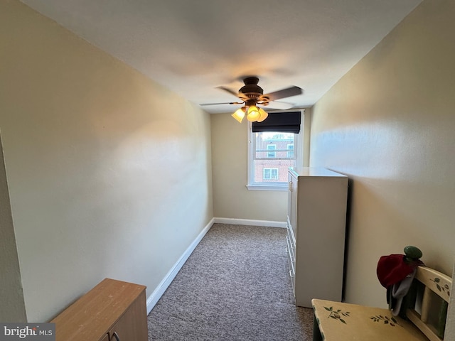 interior space with baseboards, ceiling fan, and carpet flooring