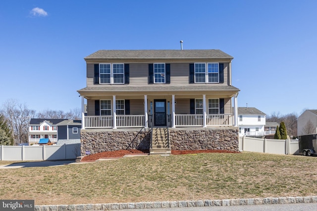 view of front of home with a porch, a front lawn, and fence