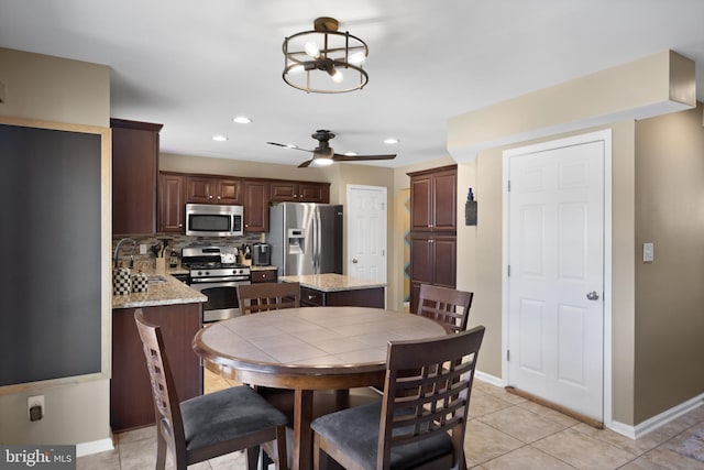 dining space with recessed lighting, ceiling fan with notable chandelier, baseboards, and light tile patterned flooring