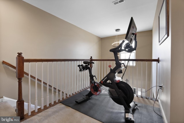 exercise room with visible vents and baseboards