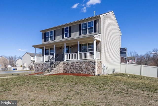 view of front of house with covered porch, a front yard, and fence