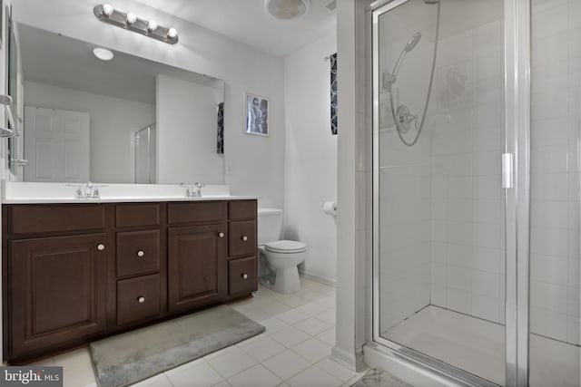 bathroom featuring double vanity, toilet, a stall shower, and a sink