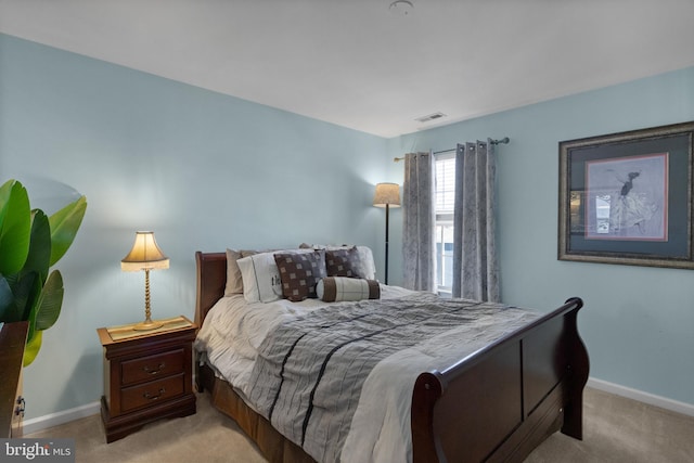 bedroom featuring visible vents, light carpet, and baseboards