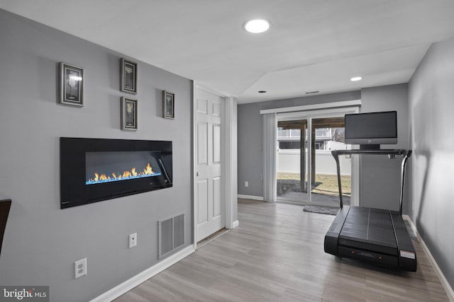 workout room featuring wood finished floors, recessed lighting, baseboards, and visible vents