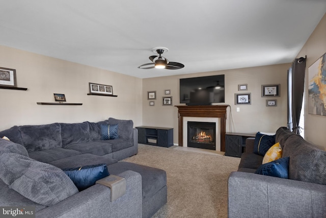 carpeted living room with a glass covered fireplace and ceiling fan