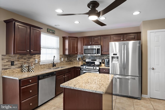 kitchen with dark brown cabinetry, light tile patterned flooring, appliances with stainless steel finishes, and a sink